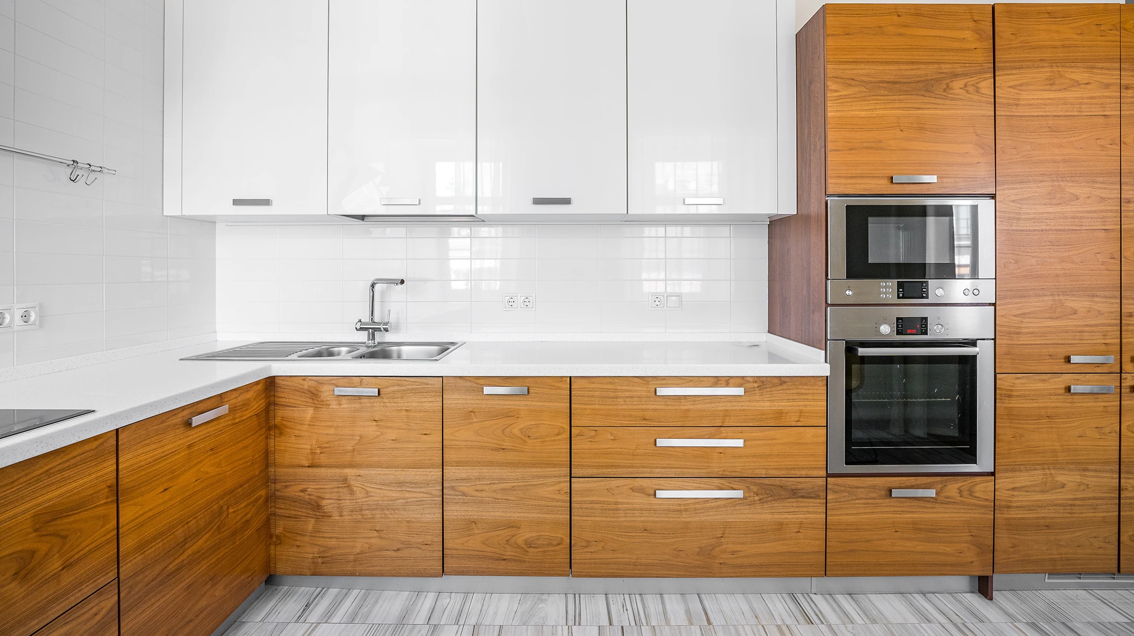 Cuisine moderne avec plan de travail en bois massif au premier plan, mobilier blanc en arrière-plan flou