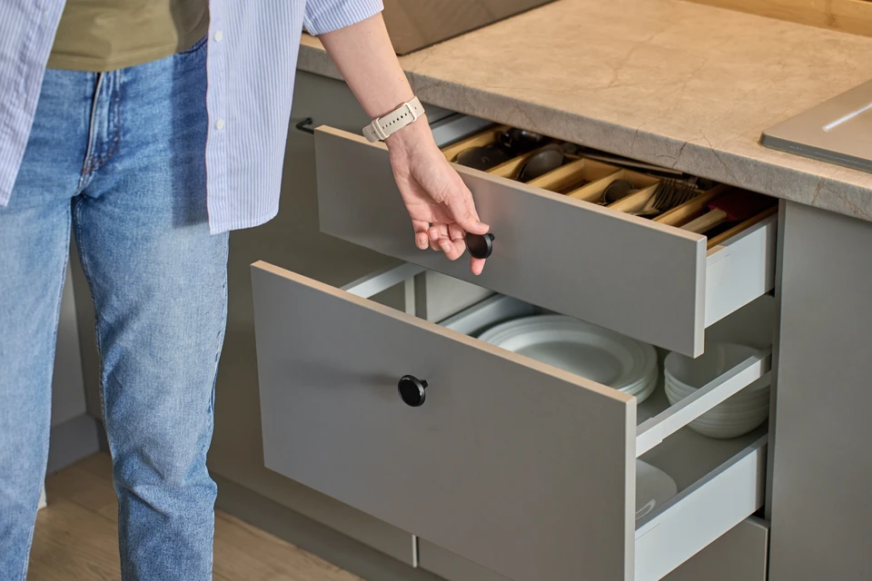 Intérieur de cuisine professionnelle avec toque de chef blanche posée sur plan de travail en bois clair