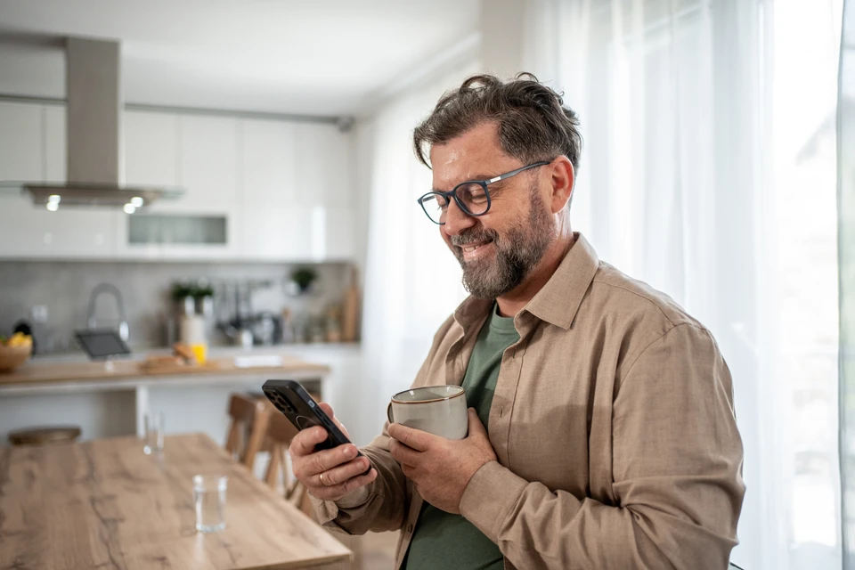 Intérieur résidentiel moderne avec personne manipulant smartphone pour contrôler éclairage connecté