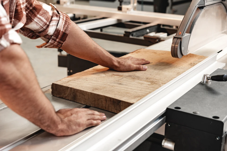 Atelier de menuiserie avec planches de bois empil&eacute;es sur &eacute;tabli